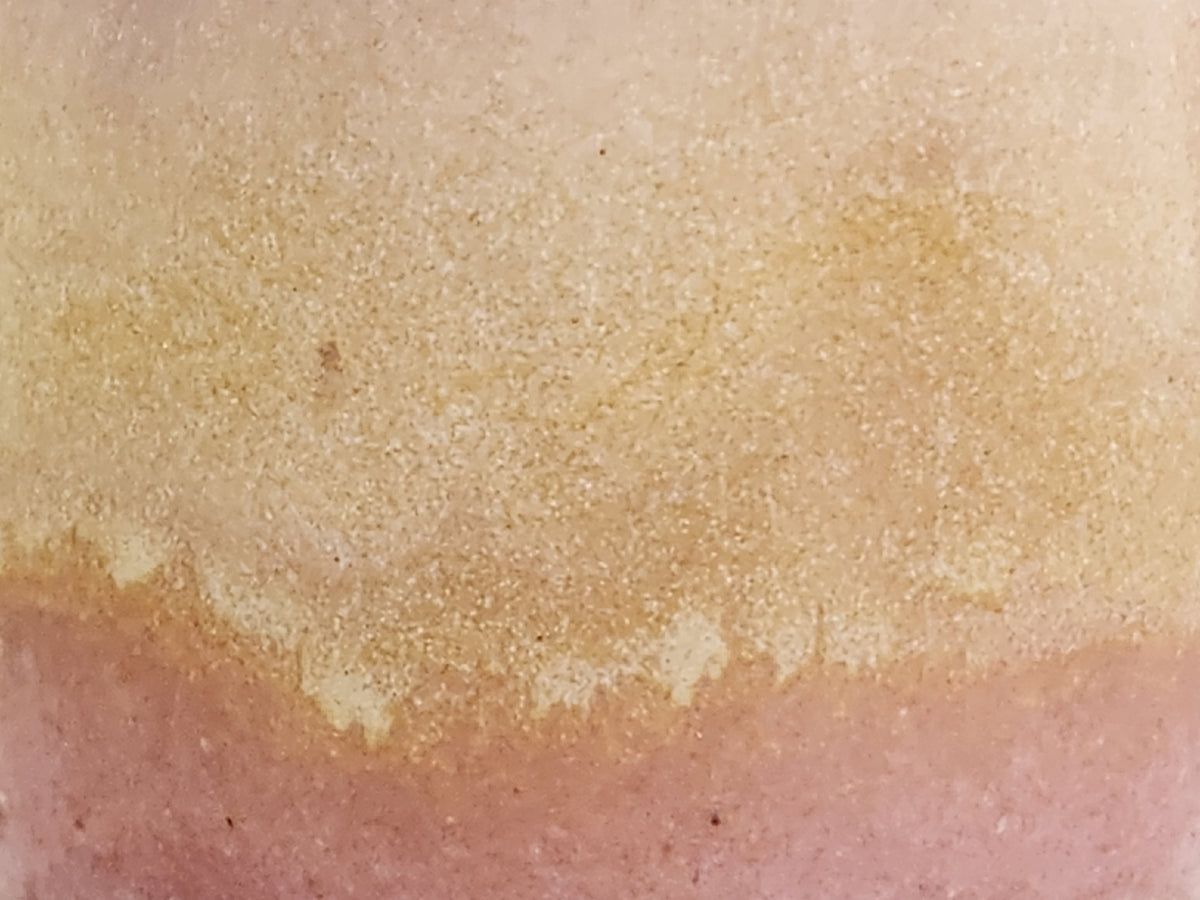 Close-up of soft pink and creamy oatmeal glaze on handmade stoneware mug