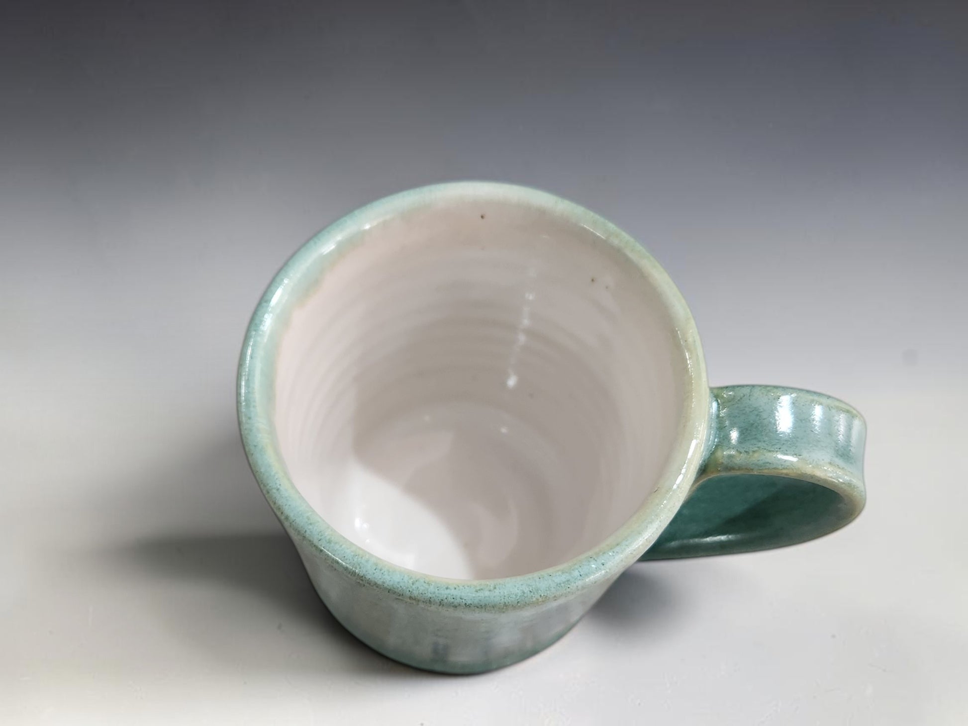 Soft green and blue mottled pottery cups holding approximately 100–120ml