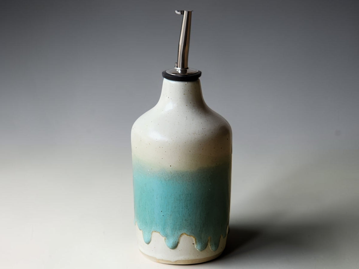 Handmade ceramic olive oil dispenser with pour spout on kitchen bench