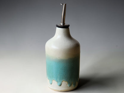 Handmade ceramic olive oil dispenser with pour spout on kitchen bench