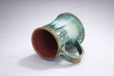 Handmade ceramic mug lying on side showing interior and base, glossy green glaze, Melbourne Australia unique gift