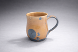 Handmade stoneware mug Melbourne amber glaze with blue crystal accents angled view