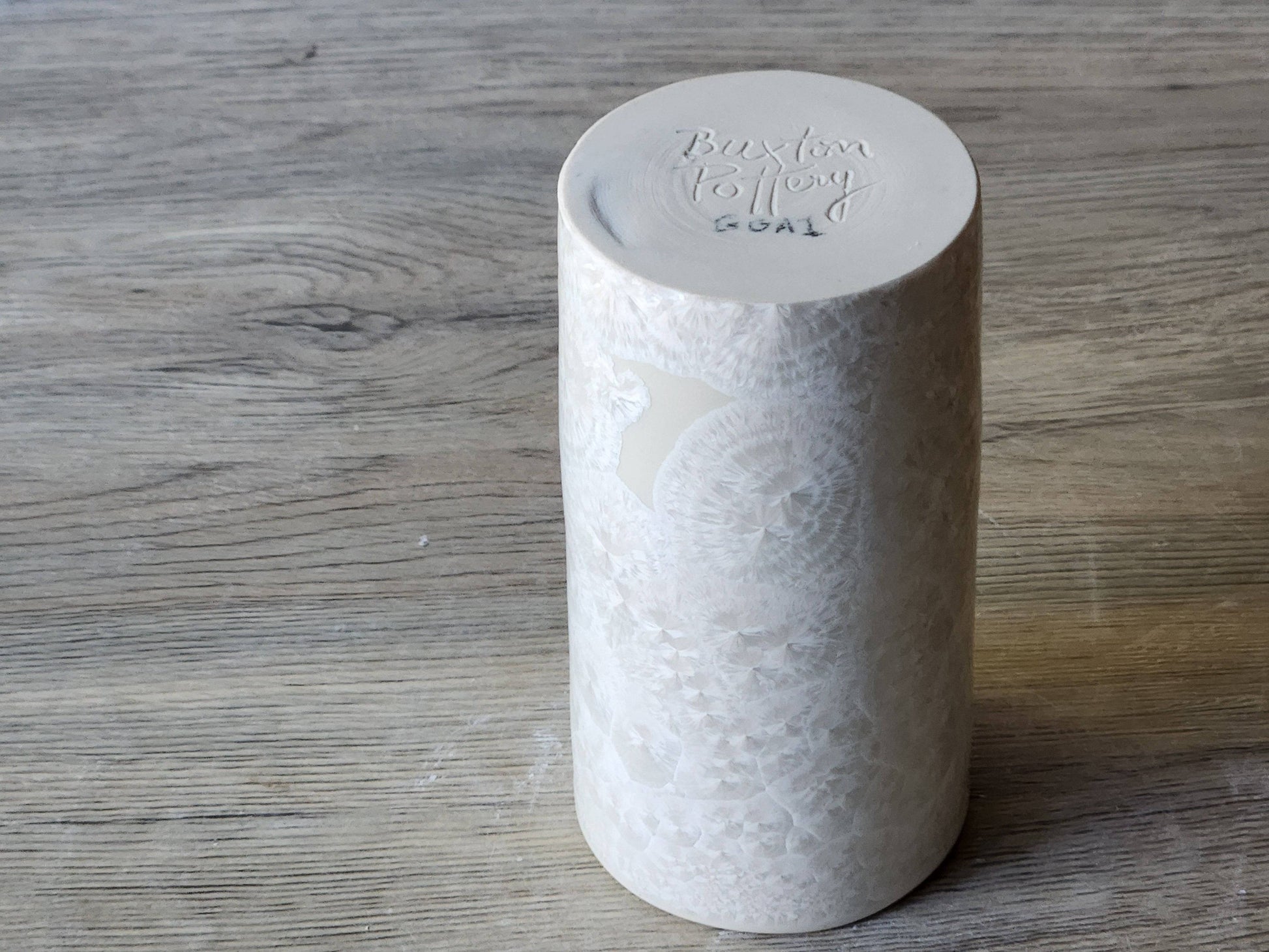 Under side of  a high-fired porcelain vase with glossy white crystalline glaze