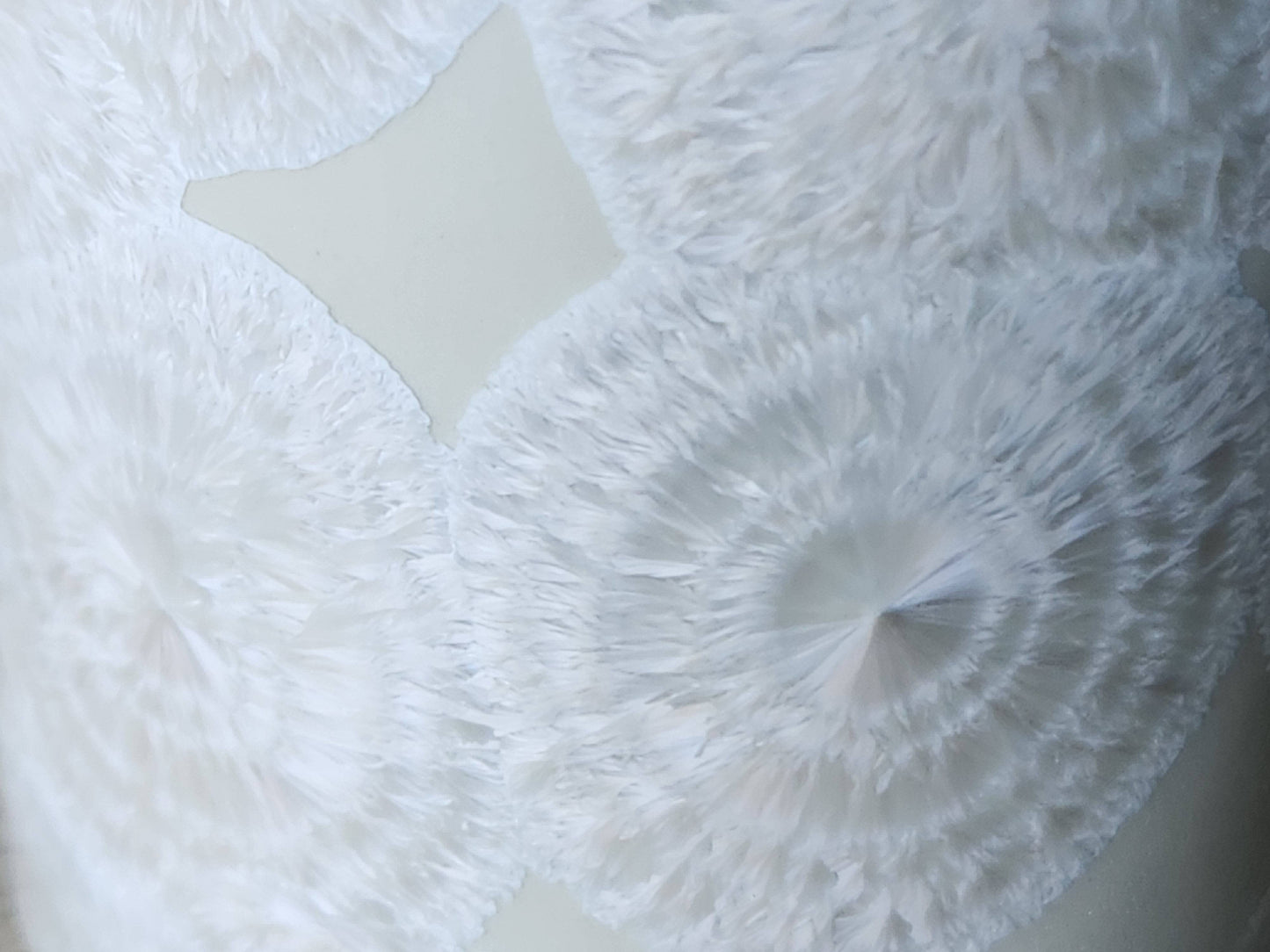 Close up of rings on the fathery crystals on a One-of-a-kind crystalline pottery tumbler – white porcelain vase