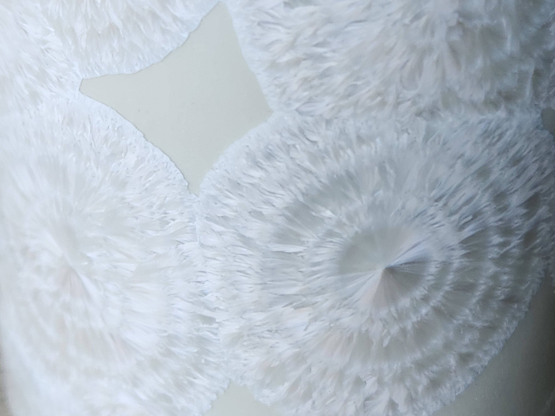 Close up of rings on the fathery crystals on a One-of-a-kind crystalline pottery tumbler – white porcelain vase