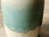 Close up of the green glaze on a handmade ceramic oil bottle