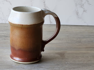 Rustic speckled cream ceramic stein with deep red-brown glaze accent