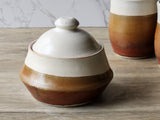 Speckled cream and red-orange ceramic sugar bowl with lid