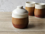 Wheel-thrown pottery container with domed lid and earthy glaze tones