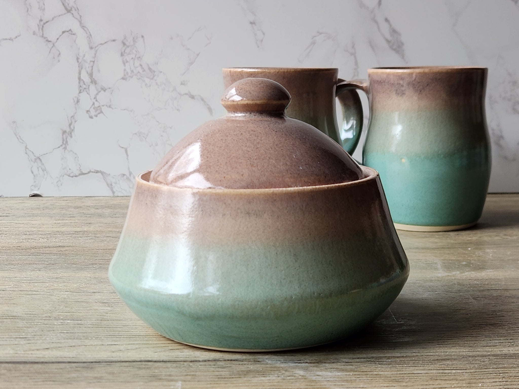 Lidded stoneware sugar bowl with domed top and earthy glaze tones