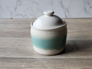 Lidded stoneware jar with soft speckled finish and vertical green accent