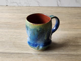 Multicolored ceramic mug on a wooden surface