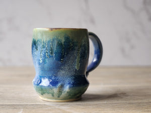 Handmade blue and green ceramic mug with ash glaze drips
