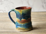 Handmade ceramic mug with layered rust and blue glaze