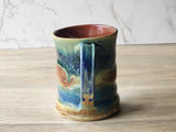 Handmade ceramic mug with layered rust and blue glaze