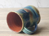Multicolored ceramic mug on a wooden surface
