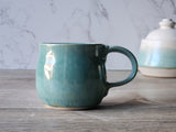 Artisan stoneware coffee mug with rounded shape and sea-grass finish