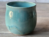 Close-up of ceramic tea mug featuring smooth turquoise and jade tones
