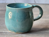 Melbourne-made handmade mug in coastal green glaze with curved handle