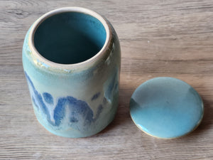 Blue ceramic jar with a matching lid on a wooden surface