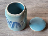 Blue ceramic jar with a matching lid on a wooden surface