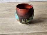 Wheel-thrown pottery cup in burgundy, brown, moss green and turquoise glazes