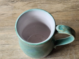Handmade stoneware mug with mottled green exterior and white interior made in Melbourne
