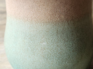 close up of glaze Comfortable handle pottery mug with glossy brown rim and green glaze
