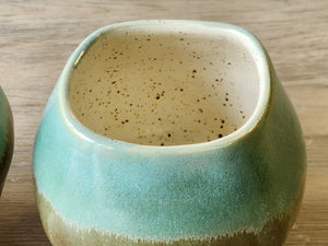 Rustic ceramic teacup with green-bronze glaze effect