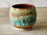Handmade ceramic tea cup with earthy brown and green glazes, made in Australia.