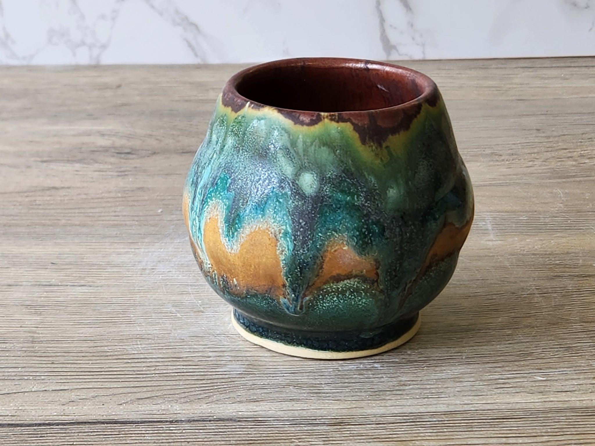 Wheel-thrown yunomi pottery cup in moss green and turquoise