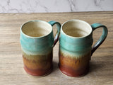 Tall pottery steins glazed in green and rust layers
