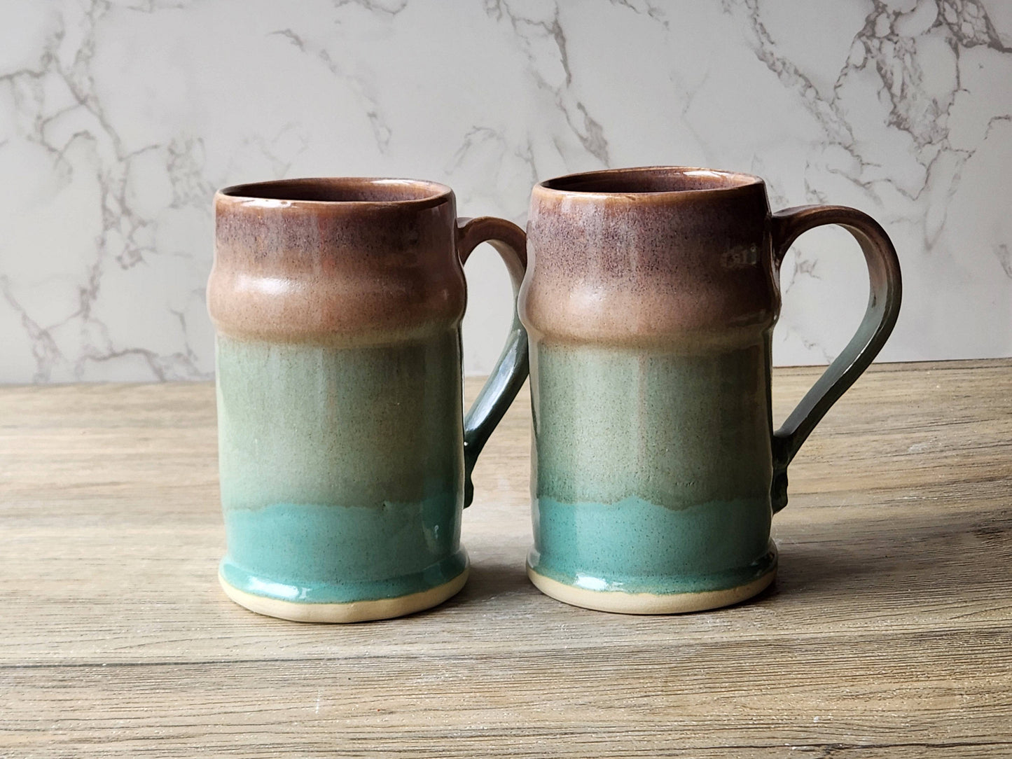 Rustic stoneware beer mugs with earthy green tones