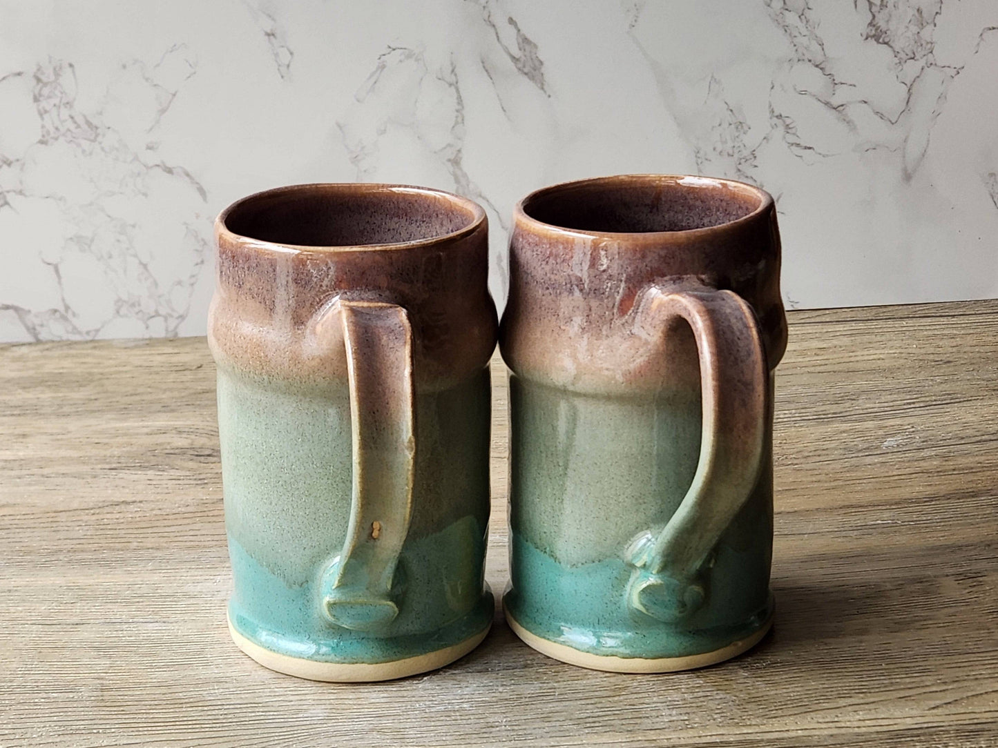 Artisan pottery steins with green and tan glaze blend