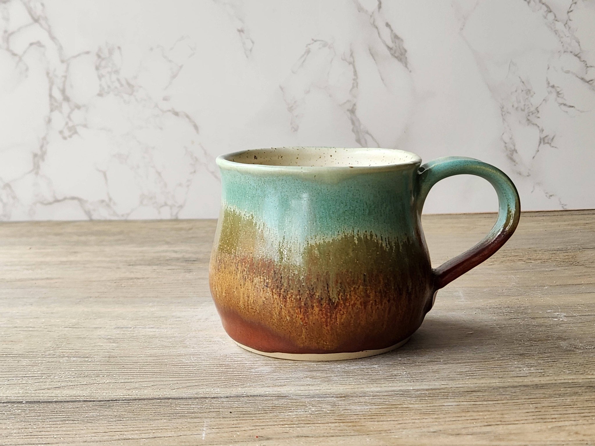 Wheel-thrown ceramic coffee mug in earthy tones