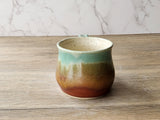 Rustic pottery mug with green brown layered glaze