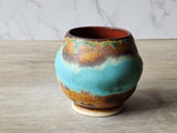 Handmade pottery tea cup with earthy turquoise glaze