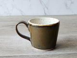 Espresso coffee cup with bronze glaze and cream interior