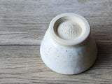 Speckled buttermilk ceramic bowl with green glaze accent