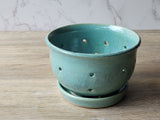 Wheel-thrown pottery berry strainer with glossy mottled glaze