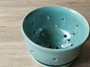 Handmade ceramic fruit bowl with drainage holes and saucer