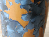 Close up of crystals on a Orange and blue crystalline pottery flower vase