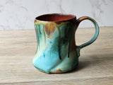 Artisan mug with sculptural finger dents and bold glaze