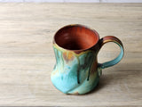 Hand-thrown ceramic mug with earthy green and red glazes