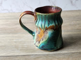 Side view of handmade ceramic cup with earthy glaze