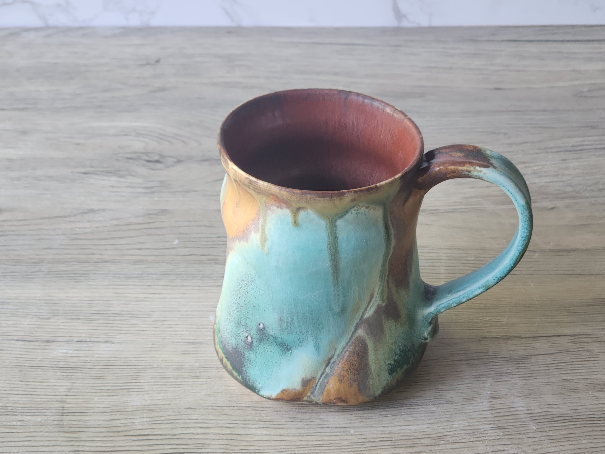 Side view of handmade ceramic cup with earthy glaze