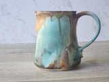 Unique pottery mug with textured surface and thumb indent