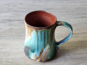 inside  of green and brown glaze drips on a rustic mug made in Melbourne.