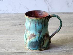 Handmade coffee mug with sculptural handle and flowing glaze