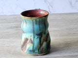 Australian-made pottery mug with fluid green and rust pattern